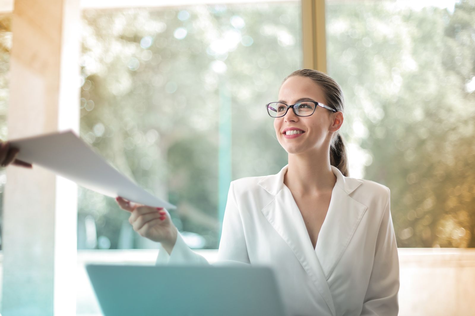 A manager handing over onboarding paperwork to a new team member